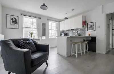 a living room with a chair and a kitchen at Edinburgh Castle Apartment G1 in Edinburgh