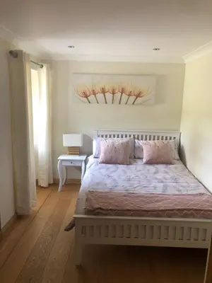 a bedroom with a bed with a painting on the wall at Old Tynribbie House - Comfortable Detached House in Appin