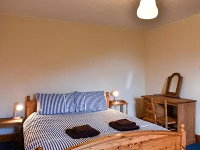 a bedroom with a bed with two towels on it at Burnside Cottage in Sliddery