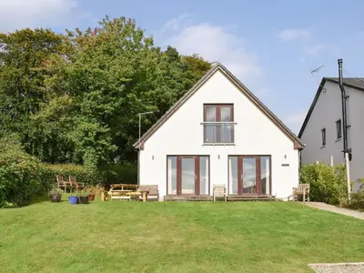 a white house with a lawn in front of it at Rivendell in Lamlash
