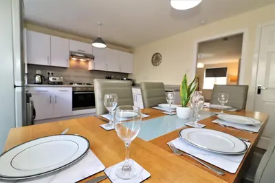 a dining room table with plates and wine glasses at Signature - Harris House in Glasgow