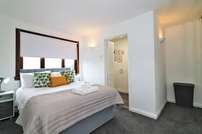 a bedroom with a large bed and a mirror at Signature - Barons Court in Paisley