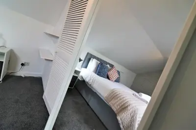 a small bedroom with a bed in a attic at Signature - Barons Court in Paisley