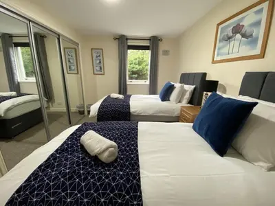 a hotel room with two beds and a couch at Pure Apartments Dunfermline East - Dalgety Bay in Saint Davids