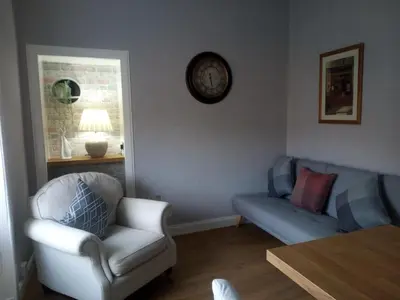 a living room with a couch and a chair at On Yer Bike & Gone Fishin in Millport