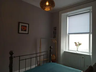a bedroom with a bed and a window at On Yer Bike & Gone Fishin in Millport