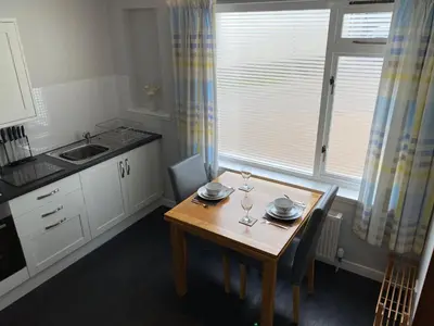 a kitchen with a table with two wine glasses on it at Edgemont Annexe Oban in Oban