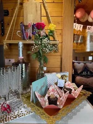 a table topped with cupcakes and a vase of flowers at FINN VILLAGE - Loch Lomond Sunset Glamping Pod - Private Ofuro HOT TUB in Drymen