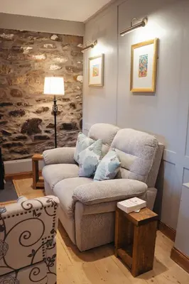 a living room with a couch and a table at Shepherds Forge, Loch Tay in Aberfeldy