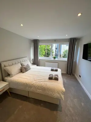 a bedroom with a large bed and a large window at Strada Apartment in Edinburgh