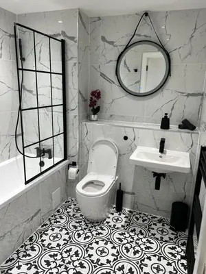 a bathroom with a toilet and a sink and a mirror at Strada Apartment in Edinburgh