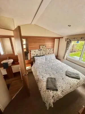 a bedroom with a bed and a sink at 2-Bedroom Caravan Located in Uddingston, Glasgow at Maryville Caravan Site in Uddingston