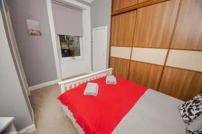 a bedroom with a bed with a red blanket at Bonhill Getaway in Dumbarton