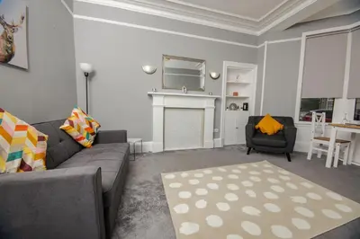 a living room with a gray couch and a fireplace at Bonhill Getaway in Dumbarton