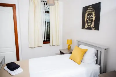 a bedroom with a white bed with a yellow pillow at Rigside House in Douglas