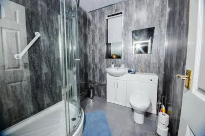 a bathroom with a sink and a toilet and a shower at Rigside House in Douglas