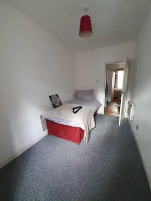 a bedroom with a bed with a red foot board at Lovely 2 bedroom flat in the heart of the city in Edinburgh