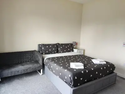 a bed and a couch in a room at My room in Edinburgh