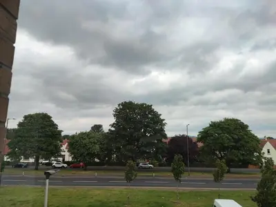 a view of a street with trees and a cloudy sky at My room in Edinburgh