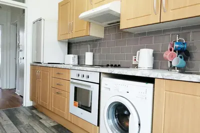 a kitchen with a washer and a washing machine at Spacious stylish centraly located flat near beach in Largs