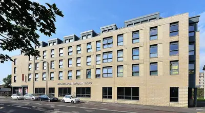 a large brick building with cars parked in front of it at HFS The Mill House Edinburgh in Edinburgh