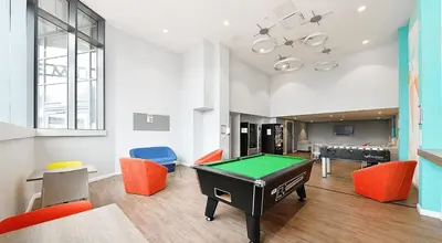 a living room with a pool table and orange chairs at HFS The Mill House Edinburgh in Edinburgh