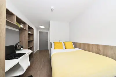 a bedroom with a bed and a desk and a laptop at HFS The Mill House Edinburgh in Edinburgh