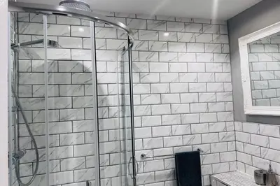 a shower in a bathroom with white tiles at Apartment with City Views - Sleeps 3 in Edinburgh