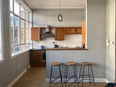 a kitchen with two bar stools and a counter at Apartment with City Views - Sleeps 3 in Edinburgh