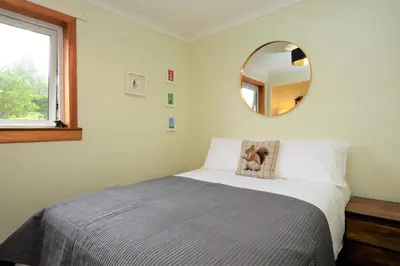 a bedroom with a bed with a mirror on the wall at Brookfield in Sandbank
