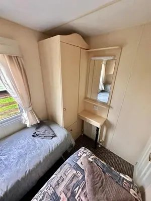 a small bedroom with a bed and a mirror at 2 Bedroom Caravan Located in Uddingston, Glasgow at Maryville Caravan Site in Uddingston