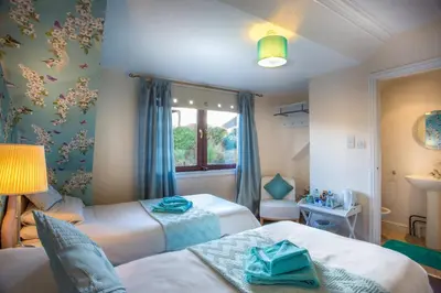 a small bedroom with two beds and a window at Neptunes Rest Guest Hotel in Stranraer