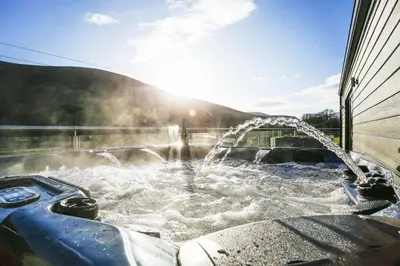a hot tub with water pouring out of it at Castlehill cabin with a hot tub in Peebles