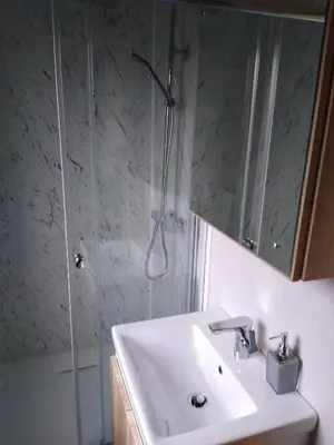 a bathroom with a sink and a shower with a mirror at The Cuddies in Balloch