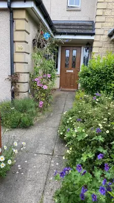a front door of a house with purple flowers at Caledonia House in Rosyth