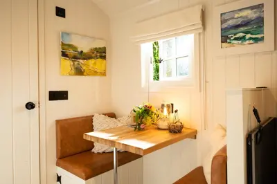 a small room with a wooden table and a window at Cosy Cute Cabin with Large Veranda & Outdoor Bath in Glasgow