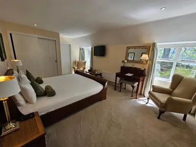 a bedroom with a bed and a desk and a chair at Taychreggan, Signature Collection by Eight Continents in Oban