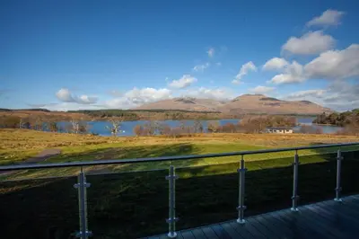a view of a lake and mountains from a balcony at New Build Lodge With Stunning Views of Loch Awe in Hayfield