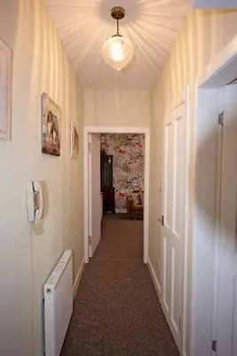 a hallway with a ceiling fan and a hallway with a door at Cosy one bedroom flat in city center in Edinburgh