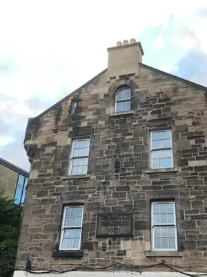 an old brick building with a sign on it at Cosy one bedroom flat in city center in Edinburgh
