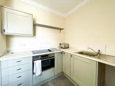 a kitchen with white cabinets and a sink at Remarkable 5BR Townhouse with Garden, Sleeps 12 in Edinburgh
