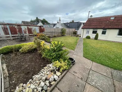 a backyard with a garden with rocks and plants at Viewlands house in Auchterarder