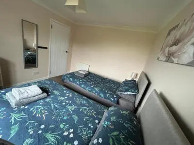 a room with two beds and a couch in it at Viewlands house in Auchterarder