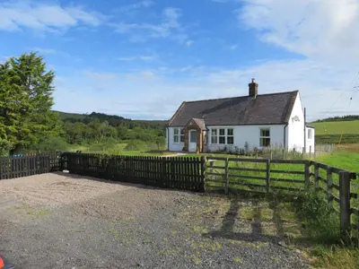 a white house with a fence in front of it at Marr Cottage in Thornhill