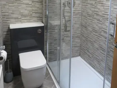 a bathroom with a toilet and a shower at Marr Cottage in Thornhill
