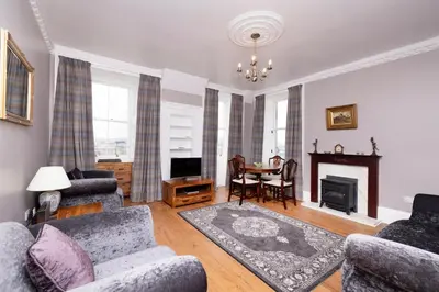 a living room with a couch and chairs and a table at JOIVY Cozy Apt near Edinburgh Castle in Edinburgh