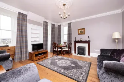 a living room with a couch and a fireplace at JOIVY Cozy Apt near Edinburgh Castle in Edinburgh