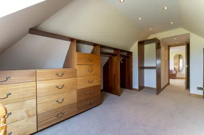 a attic room with wooden dressers and a staircase at St Michael's in Kippen