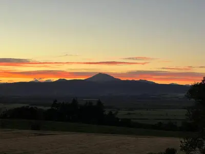 a sunset with a mountain in the distance at St Michael's in Kippen
