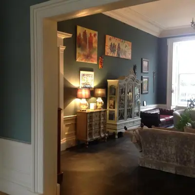a living room with blue walls and a couch at A Room in the City - West in Edinburgh